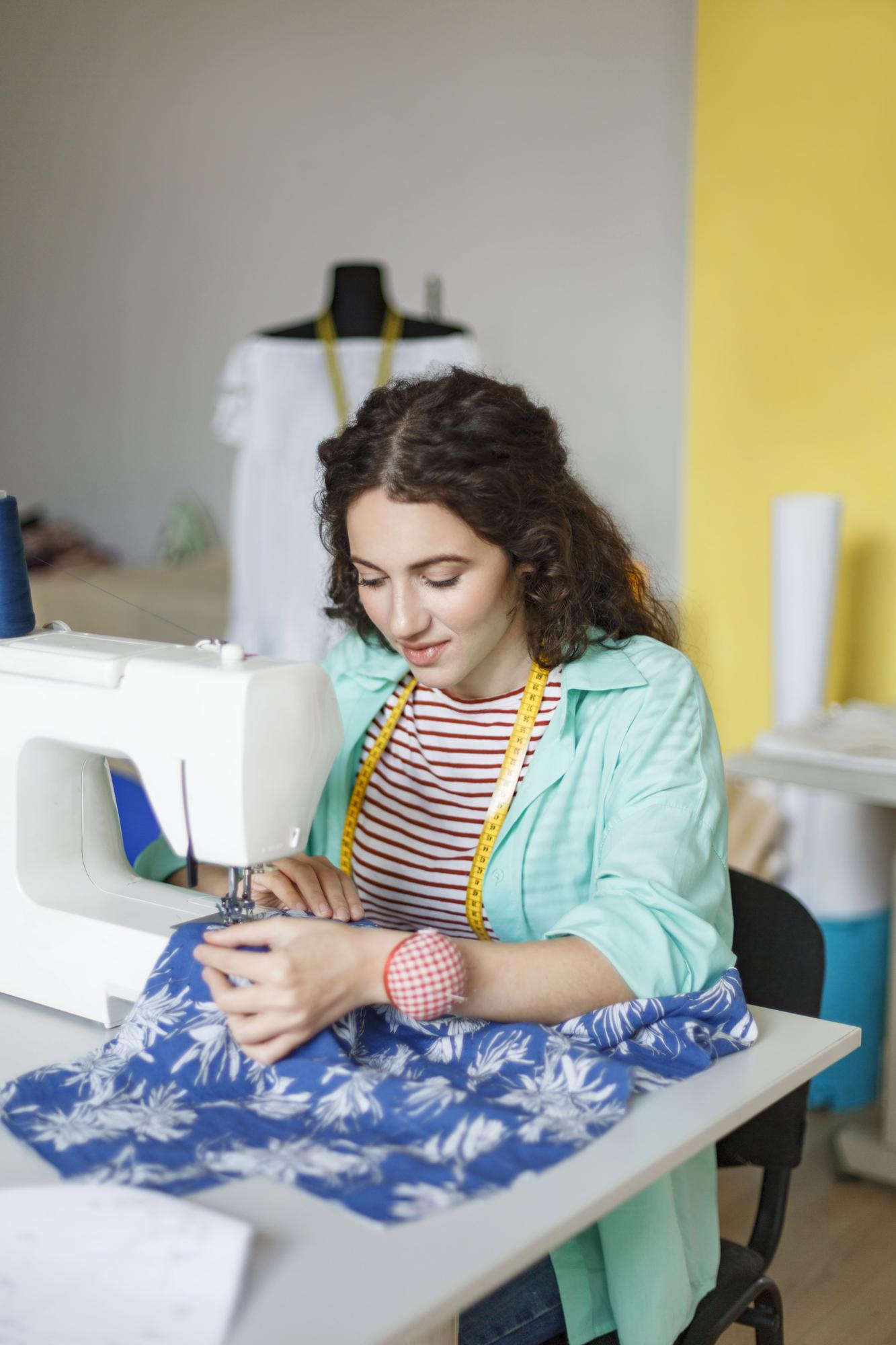 Costureira trabalhando em máquina de costura no ateliê